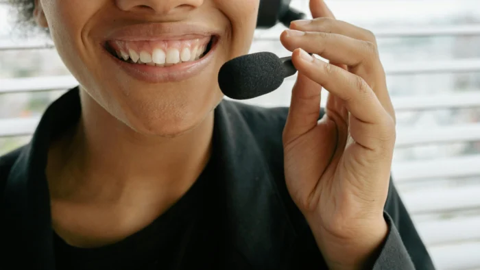 Smiling woman with Deepbite braces holding microphone